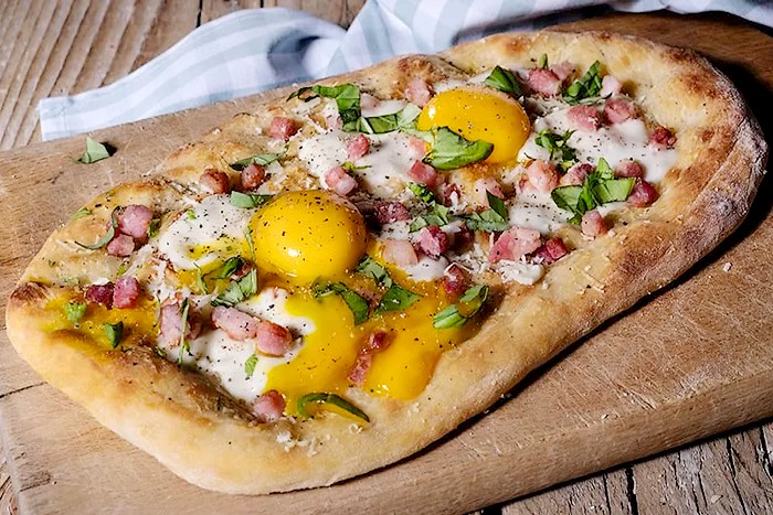Pizza carbonara avec œufs, bacon et copeaux de pecorino