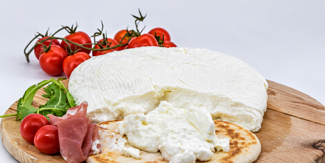 Squacquerone crémeux servi avec une piadina, des tomates et de la roquette